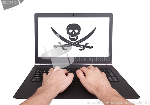 Image of Man working on laptop, piracy