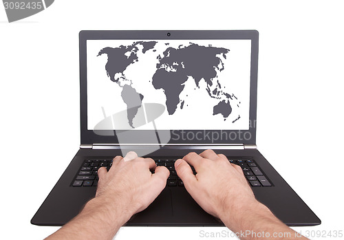 Image of Man working on laptop, world map