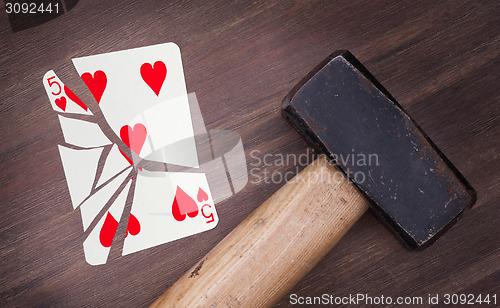 Image of Hammer with a broken card, five of hearts