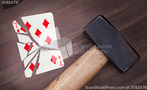 Image of Hammer with a broken card, seven of diamonds