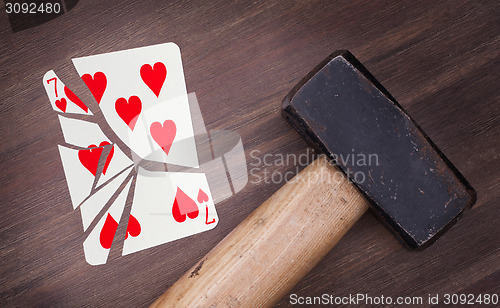 Image of Hammer with a broken card, seven of hearts