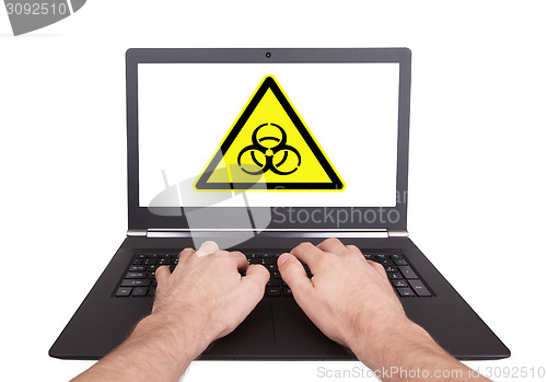 Image of Man working on laptop, biohazard