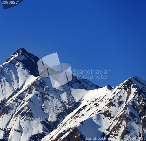 Image of Snowy sunlight rocks in evening