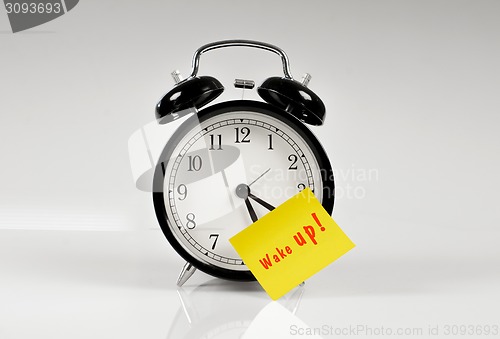 Image of Alarm clock with a yellow note