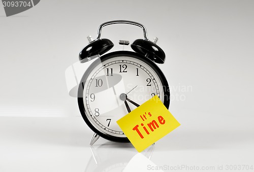 Image of Alarm clock with a yellow note