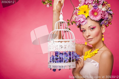 Image of Healthy girl with a birdcage and flowers