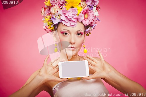 Image of Spring flowers girl is holding smartphone in hands