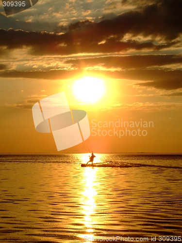 Image of Silhouette of a kitesurf on a gulf on a sunset