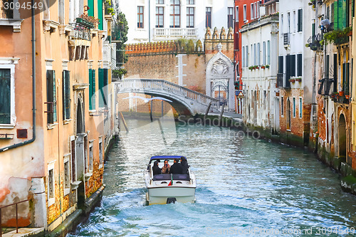 Image of Boat with tourists sailing in water canal
