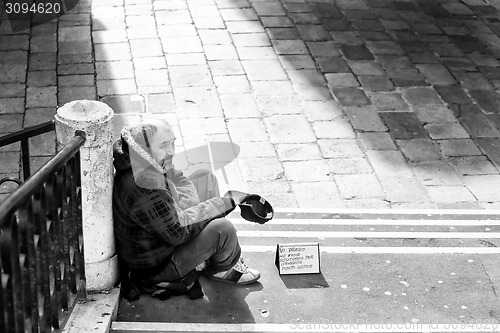 Image of Beggar sitting on stairs in Venice bw