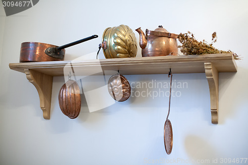 Image of kitchen shelf with old copper utensils