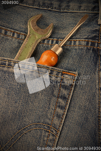 Image of wrench and a screwdriver in his pocket jeans workers