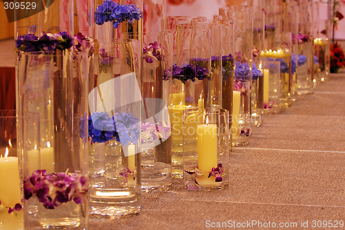 Image of Row of different vases with flowers and candles