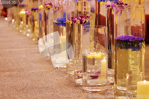 Image of Row of different vases with flowers and candles