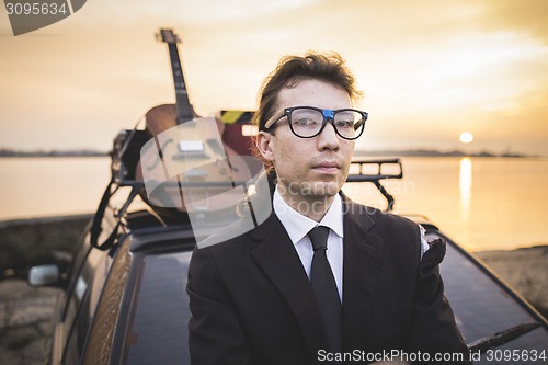 Image of Hipter in glasses and his guitar on car rack