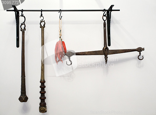 Image of kitchen railing with old copper scales and utensils