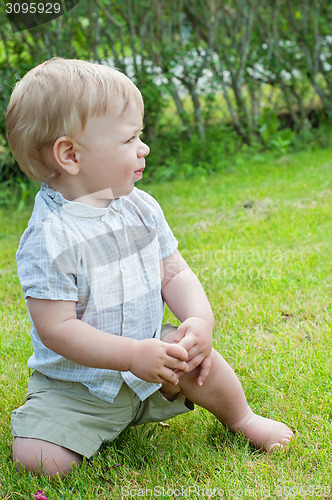 Image of Baby boy sitting on green grass