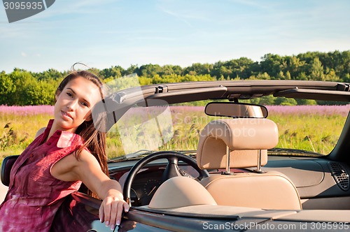 Image of Beautiful brunette female near car