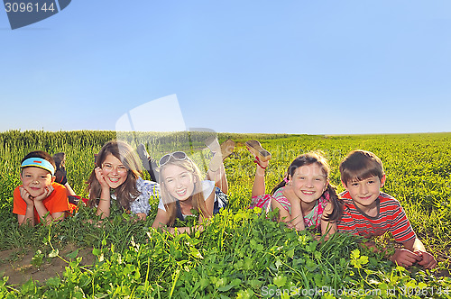 Image of happy kids laying in the field