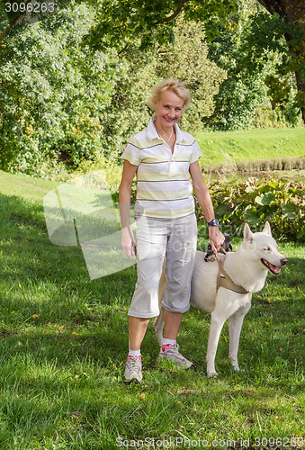 Image of Woman with a dog on a walk in the park