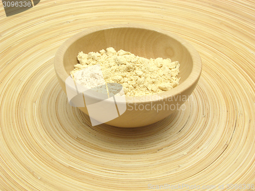 Image of Wooden bowl with soy meal on bamboo plate