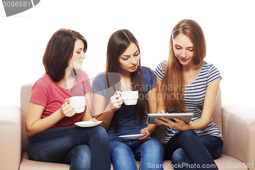 Image of Three girls friends using tablet