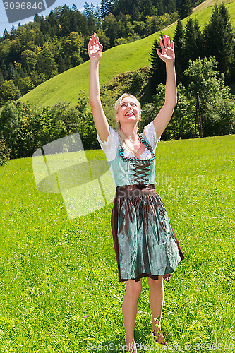 Image of Attractive blonde woman in a dirndl is full of joy