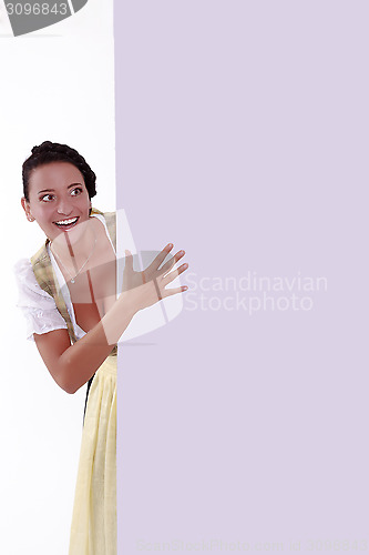 Image of Beautpeekingiful young woman  out behind wall of office or school 