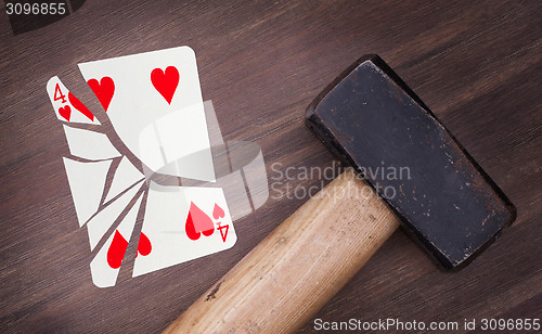 Image of Hammer with a broken card, four of hearts