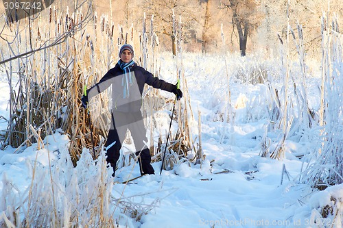 Image of Boy cross country skiing in forest at sunny winter day