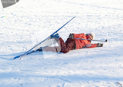 Image of young beauty girl dropped on snow while skies 