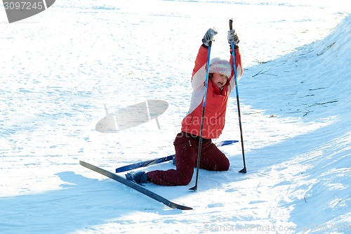 Image of young beauty girl standing up after drop on snow while skies 