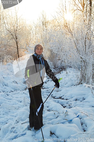 Image of Boy cross country skiing in forest at sunny winter day