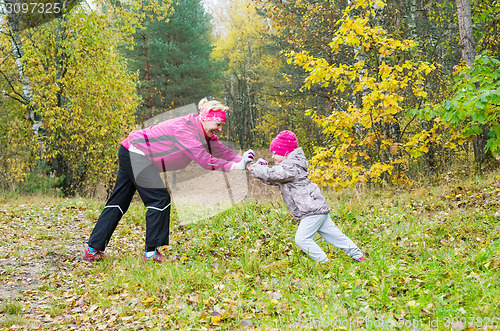 Image of Woman with girl doing aerobics in the autumn park