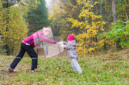 Image of Woman with girl doing aerobics in the autumn park
