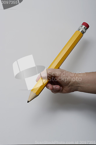 Image of hand gripping a large pencil 