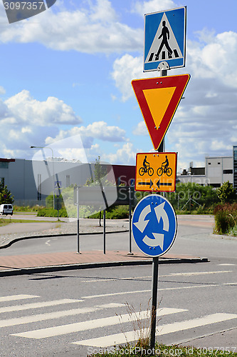 Image of road signs at intersection roundabout