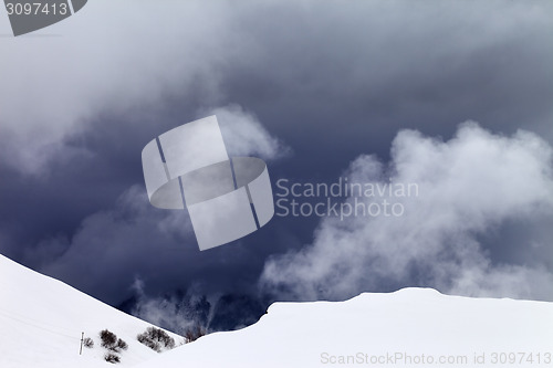 Image of Off-piste slope and storm gray clouds
