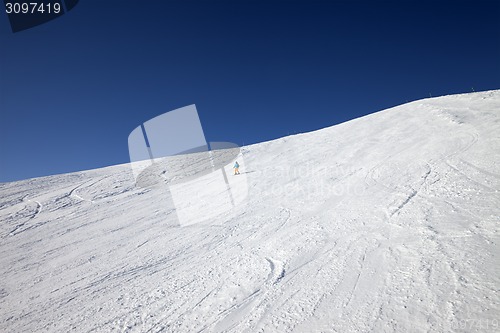 Image of Skier on slope in sun day