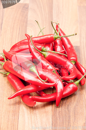 Image of Red chili on wooden chopping board