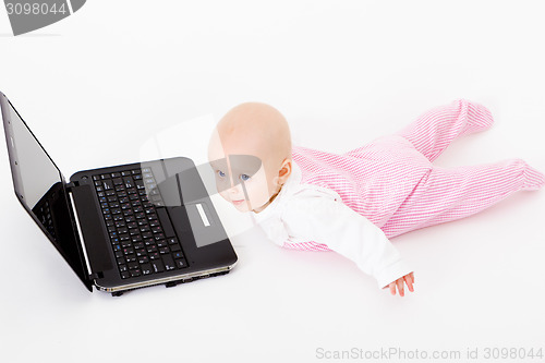 Image of baby with laptop. studio photo
