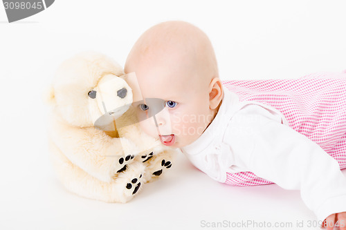 Image of blue-eyed baby with a soft toy. studio photo