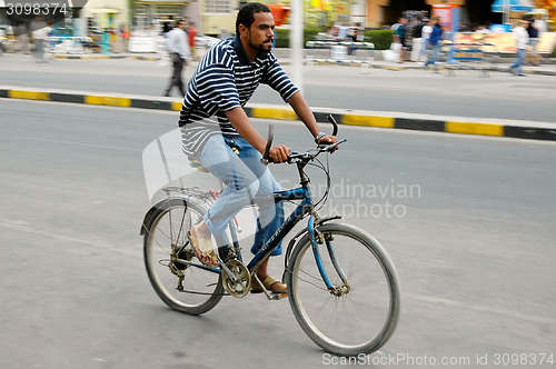 Image of Man goes by bicycle down street of Hurghada