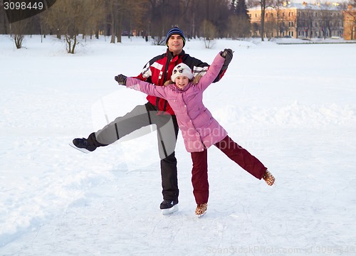 Image of Happy family on skating rink outdoors