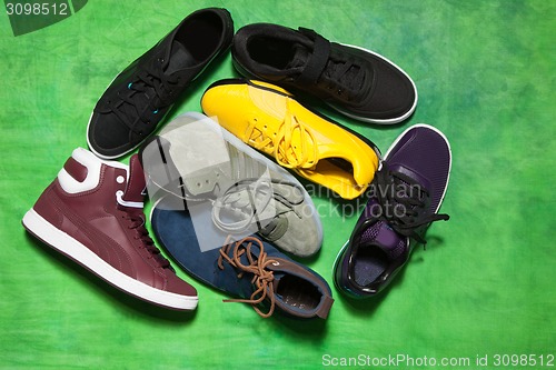 Image of Set of man footwear on a green background