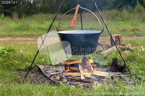 Image of Camp fire outdoors burning with pot