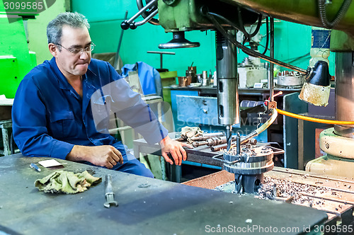 Image of Senior milling machine operator works at machine