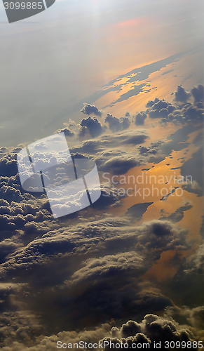 Image of Earth view from above with clouds and sea reflections