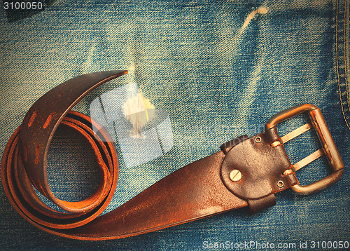 Image of vintage belt on old blue jeans