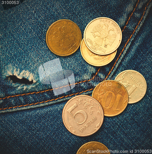 Image of jeans pocket with hole and coins